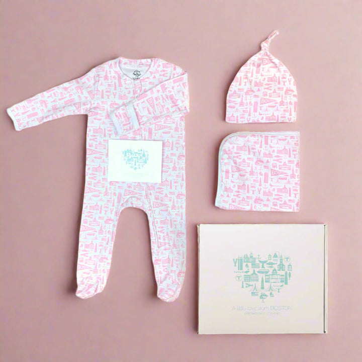 Soft cotton Boston themed pink and white baby apparel gift set which includes a zipper long sleeve onesie a knit baby hat and a baby blanket along with a gift box and note card