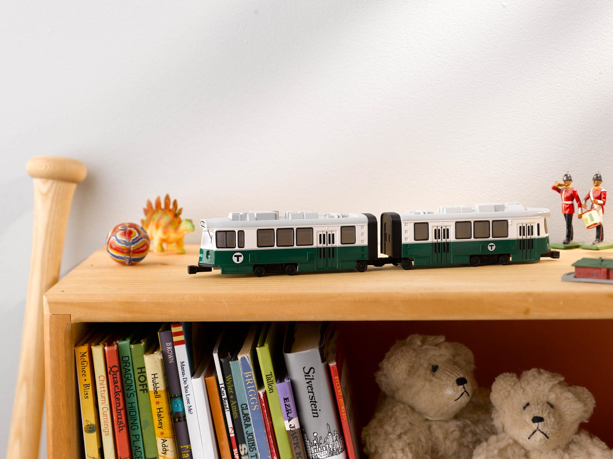 Two linked die cast mini MBTA Trolleys on a bookshelf